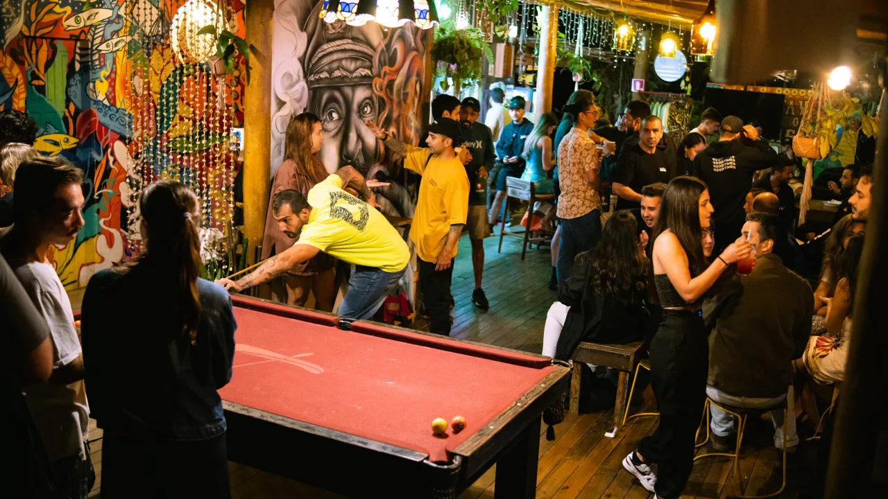 Programação noturna no Floresta Bar do Hostel da Vila em Ilhabela, com música, sinuca e hóspedes reunidos