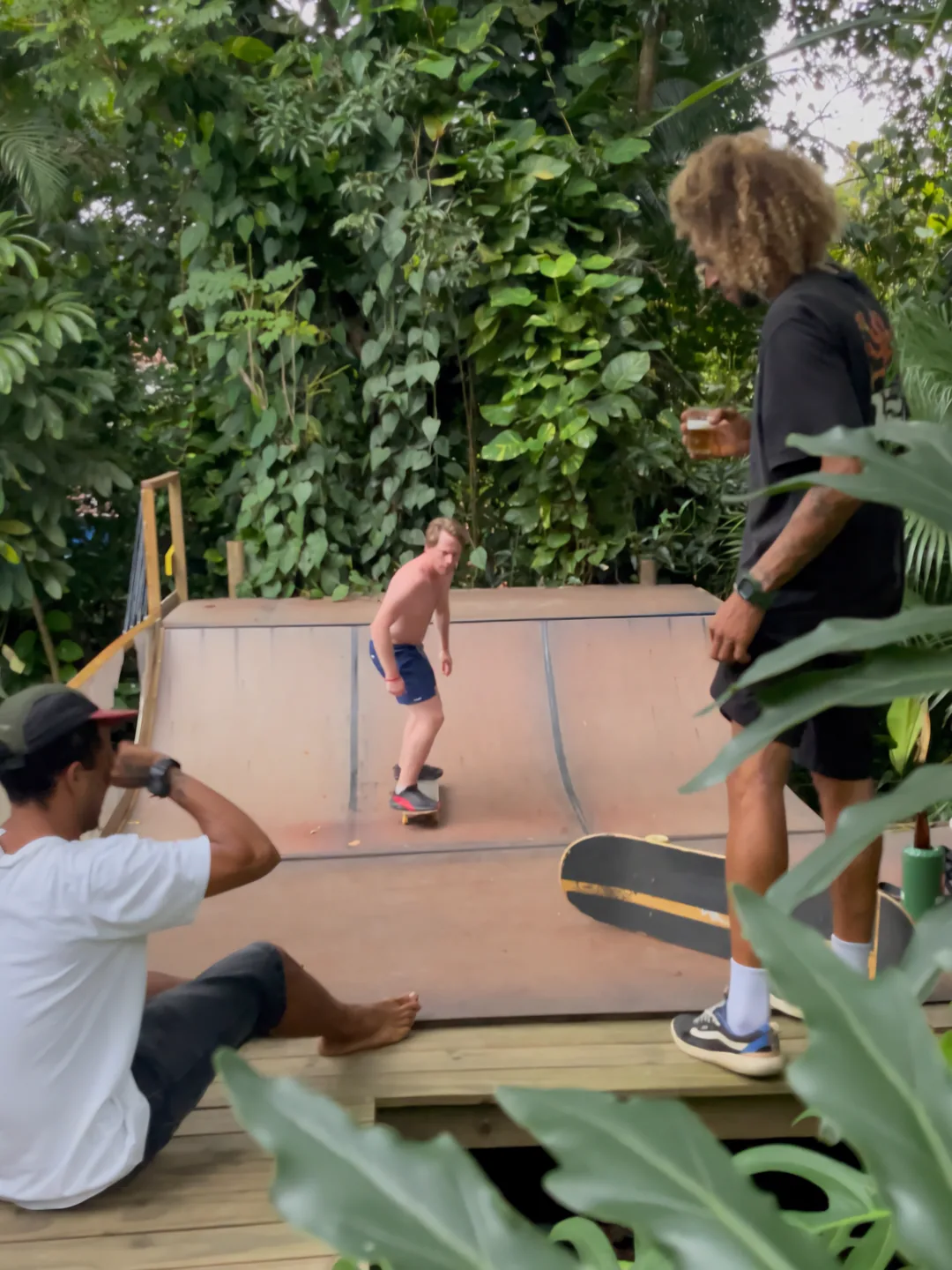 Hóspede andando de skate na mini rampa cercada de mata do Hostel da Vila em Ilhabela