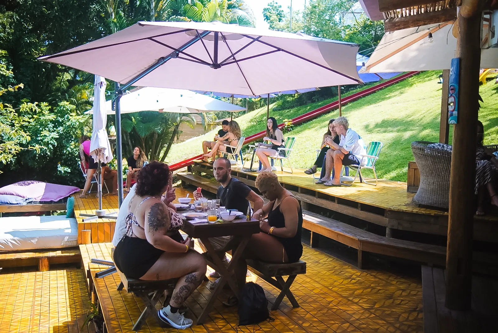 Hóspedes tomando café da manhã no deck do Hostel da Vila em Ilhabela