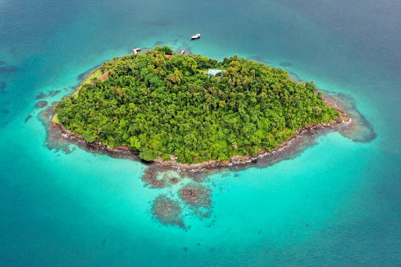 Vista aérea de ilha coberta de mata e mar turquesa na baía de Angra dos Reis