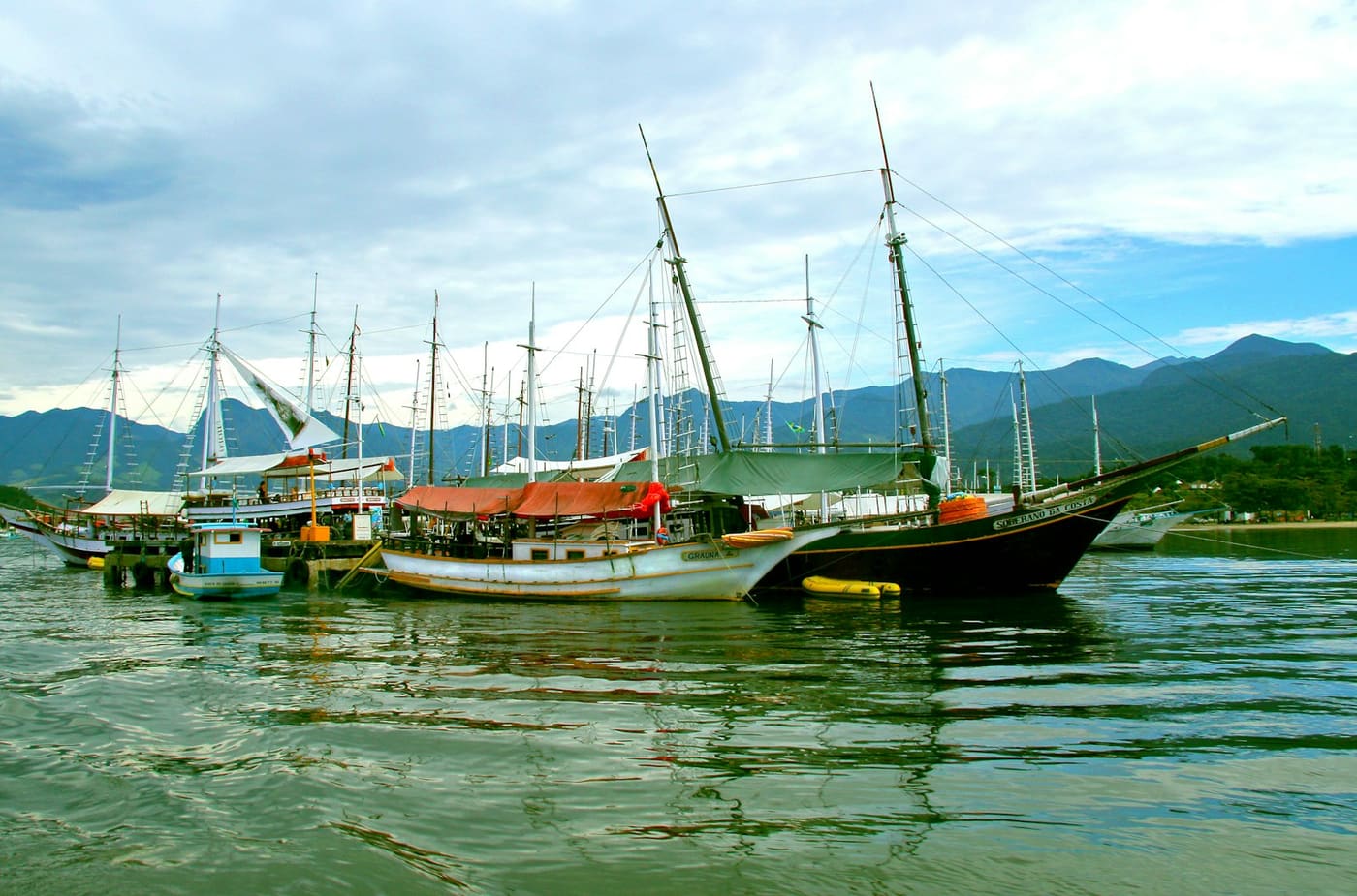 Barcos de passeio coloridos atracados no cais de Paraty