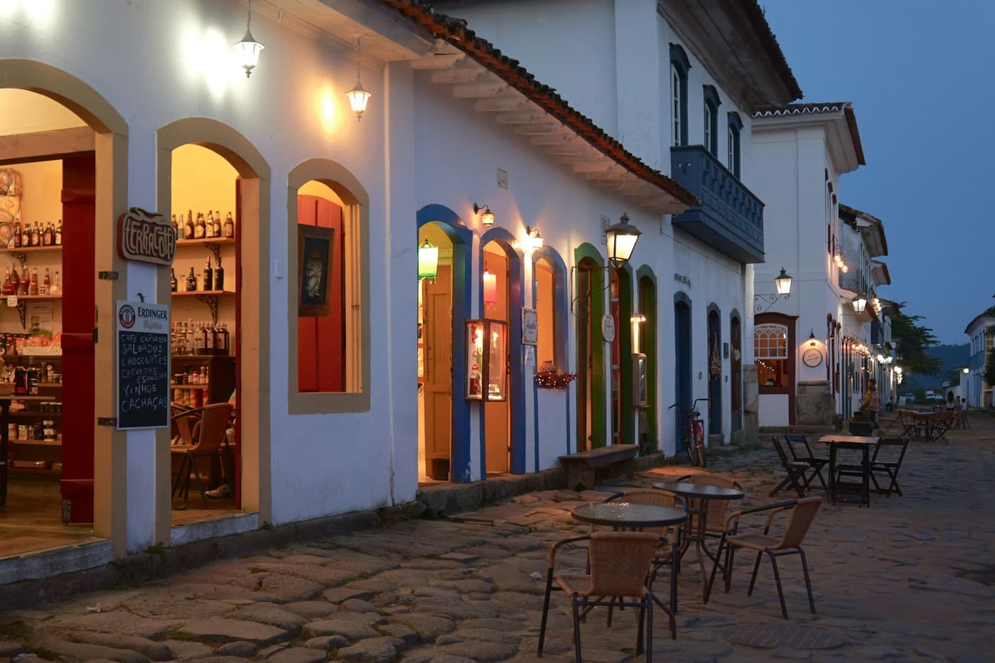 Rua de pedra do centro histórico de Paraty com casario colonial branco e portas coloridas