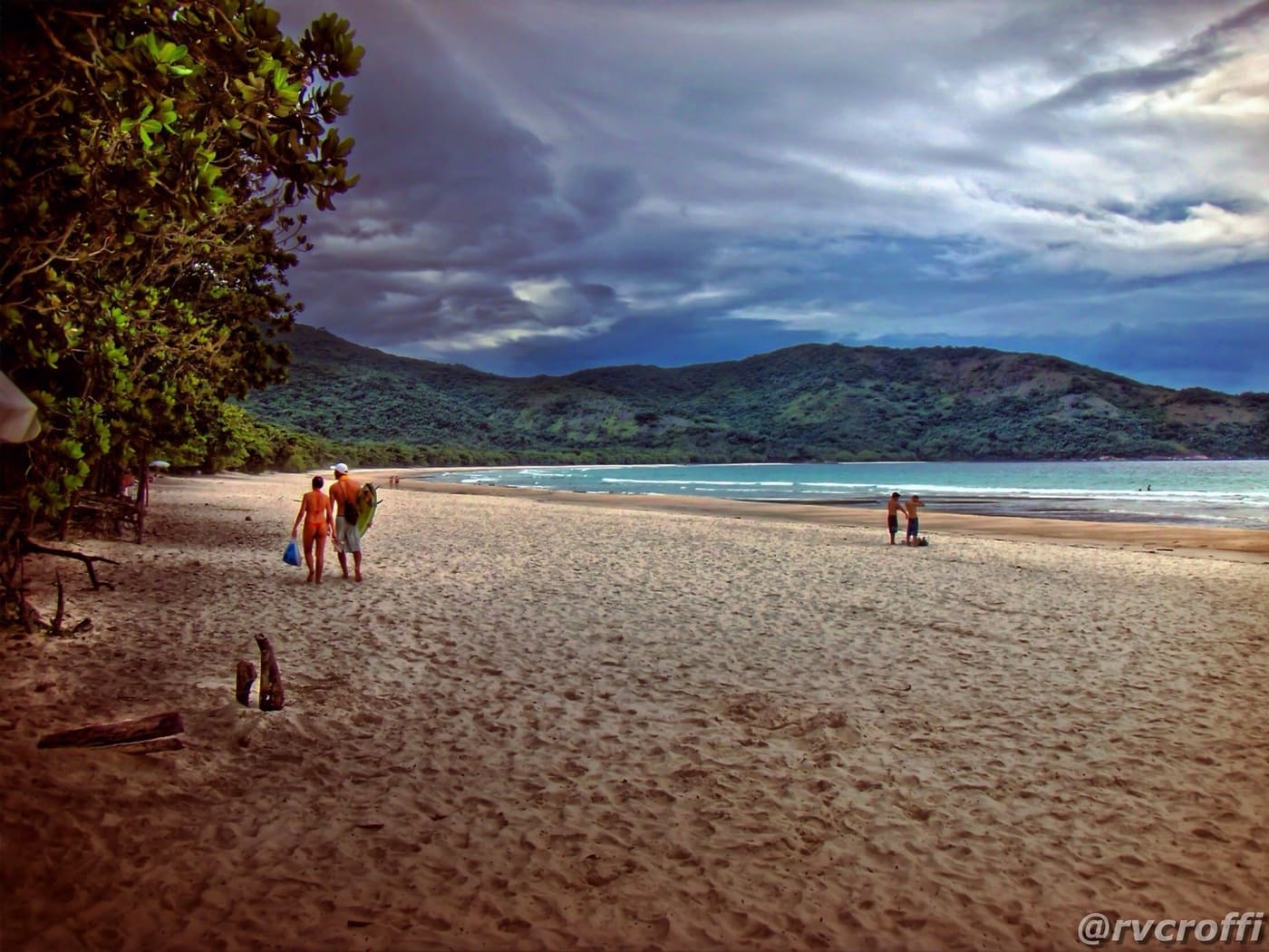 Faixa longa de areia branca e mar aberto esverdeado na praia de Lopes Mendes, Ilha Grande