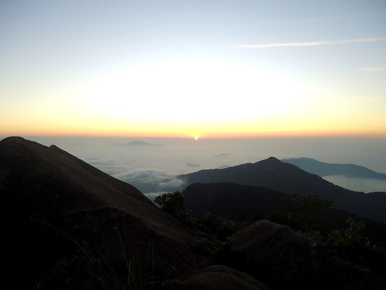 Amanhecer visto do Pico do Papagaio, com o mar e as ilhas da baía abaixo das nuvens
