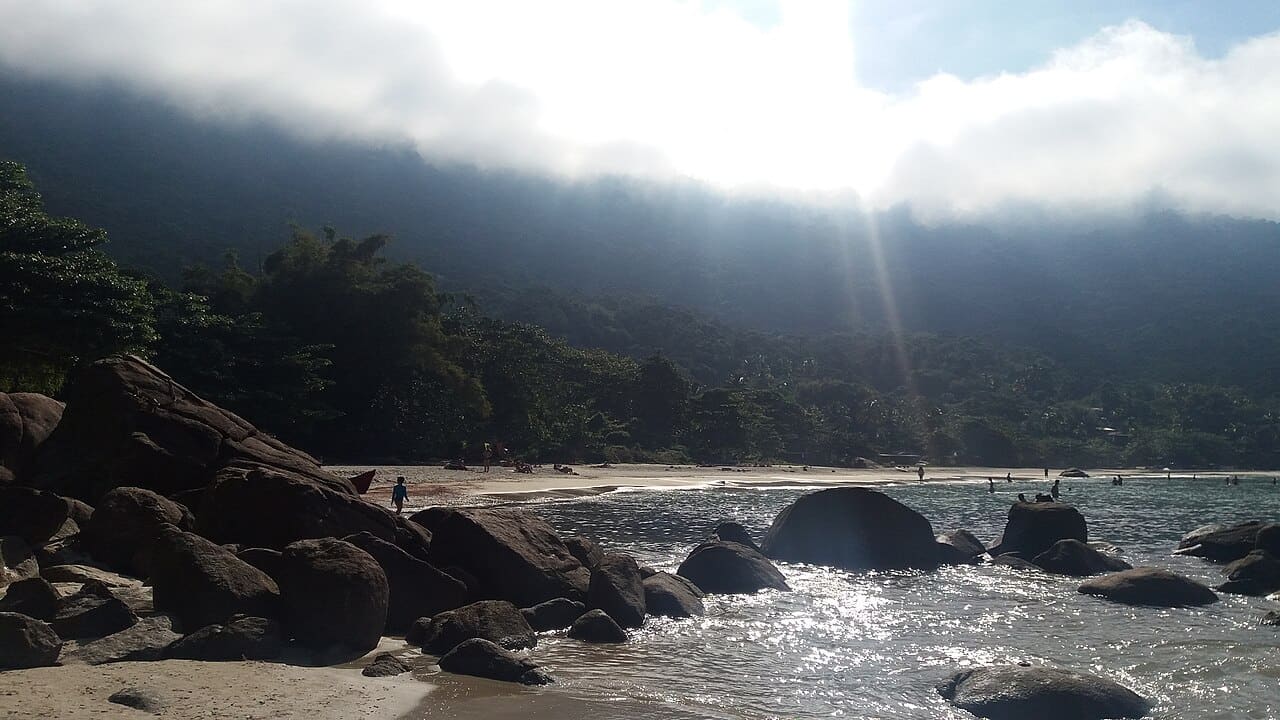 Praia do Aventureiro, na Ilha Grande, com areia clara e morros verdes ao fundo