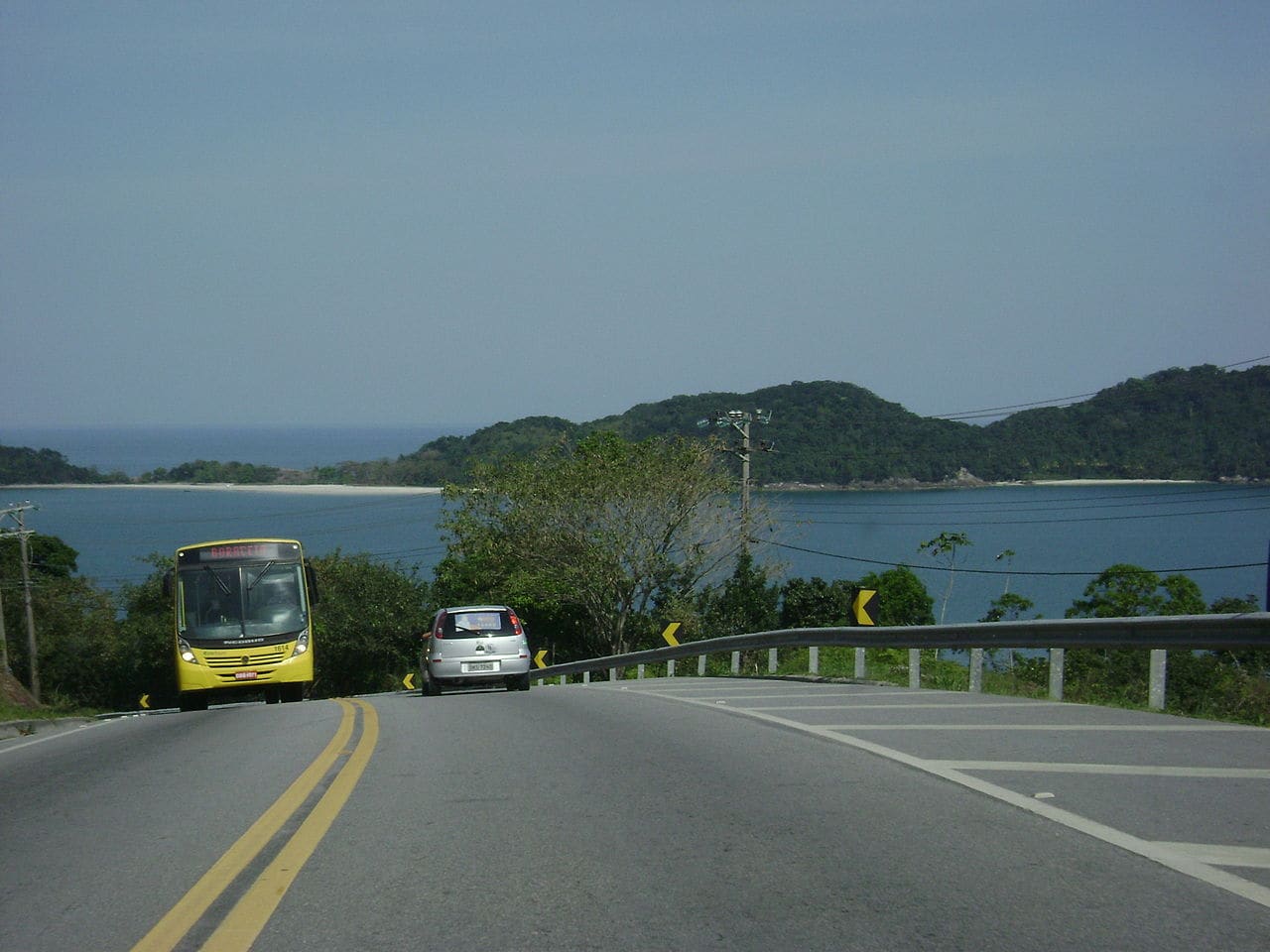 Trecho da rodovia Rio-Santos margeando o mar, com ilhas ao fundo, em São Sebastião