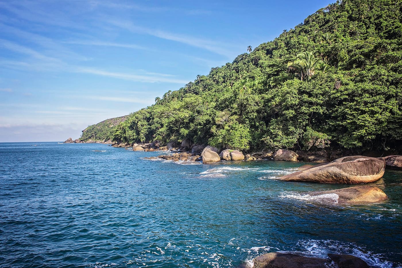 Praia do Cachadaço em Trindade, com pedras arredondadas e Mata Atlântica fechando a enseada