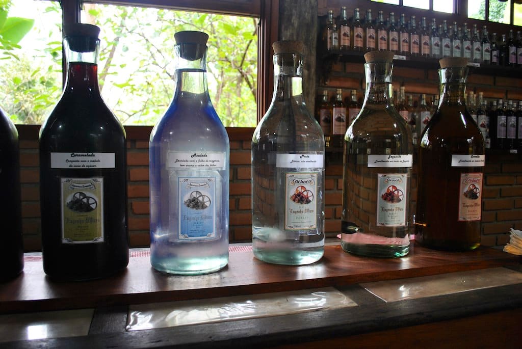 Interior de alambique de cachaça em Paraty, com alambique de cobre e barris de madeira