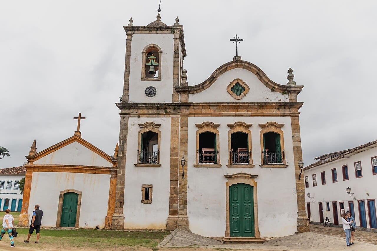 Igreja de Santa Rita em Paraty, branca com detalhes amarelos, sob céu azul